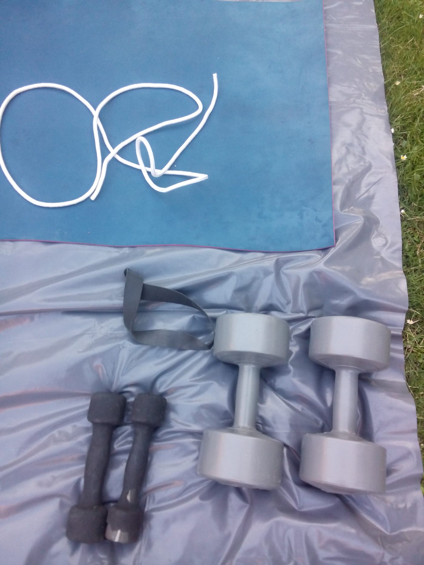 two sets of dumbells a skipping rope and a yoga mat